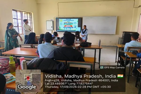 कक्षा में स्क्रीन पर सेवा संकल्प अभियान का पोस्टर देखते विद्यार्थी, सामने खड़ी छात्रा और शिक्षक